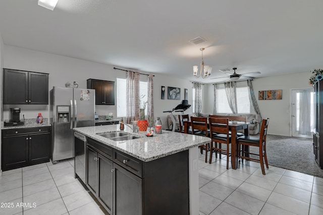 kitchen with appliances with stainless steel finishes, sink, a kitchen island with sink, and light tile patterned floors