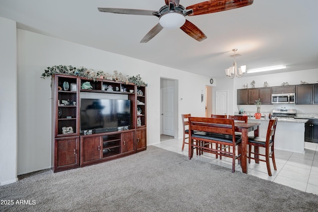 carpeted living room with ceiling fan with notable chandelier