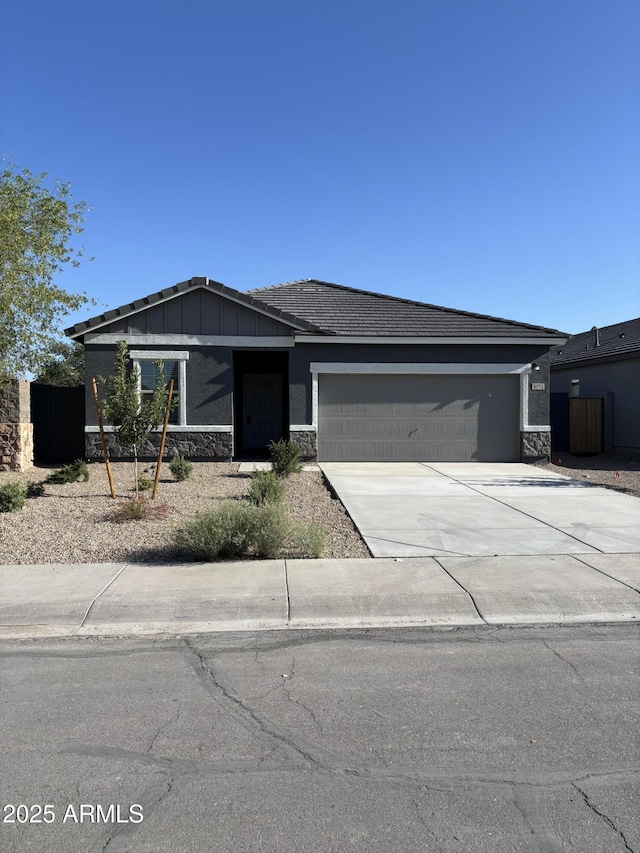 6113 E Artemis Dr, Florence, AZ 85132 - view of front of property featuring stone siding, an attached garage, concrete driveway, and board and batten siding