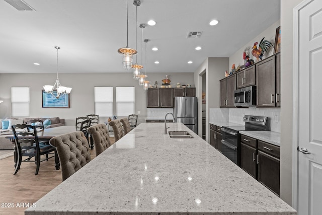 4244 Sawbuck Way, Wickenburg, AZ 85390 - kitchen featuring a notable chandelier, a spacious island, open floor plan, stainless steel appliances, and visible vents