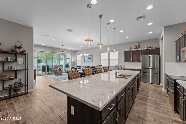 4244 Sawbuck Way, Wickenburg, AZ 85390 - kitchen with a sink, visible vents, light wood-style floors, and appliances with stainless steel finishes