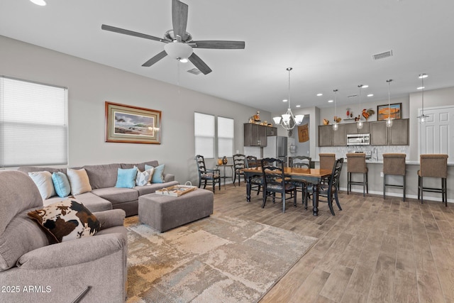 4244 Sawbuck Way, Wickenburg, AZ 85390 - living room featuring ceiling fan with notable chandelier, visible vents, light wood-style flooring, and recessed lighting