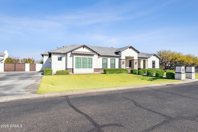 modern farmhouse style home with fence, a front lawn, board and batten siding, and brick siding