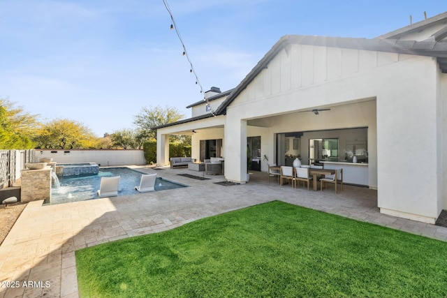 exterior space with a patio, a pool with connected hot tub, a lawn, a ceiling fan, and an outdoor living space