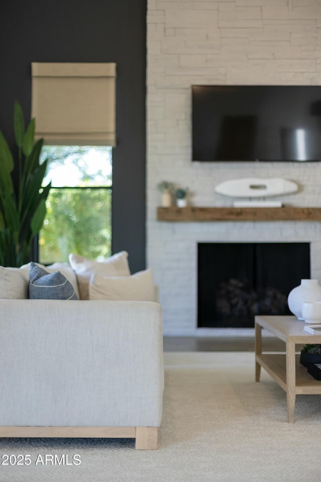 carpeted living area with a large fireplace