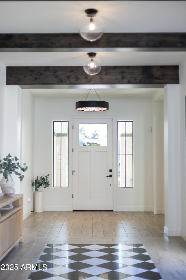 entryway with beamed ceiling, a wealth of natural light, and baseboards