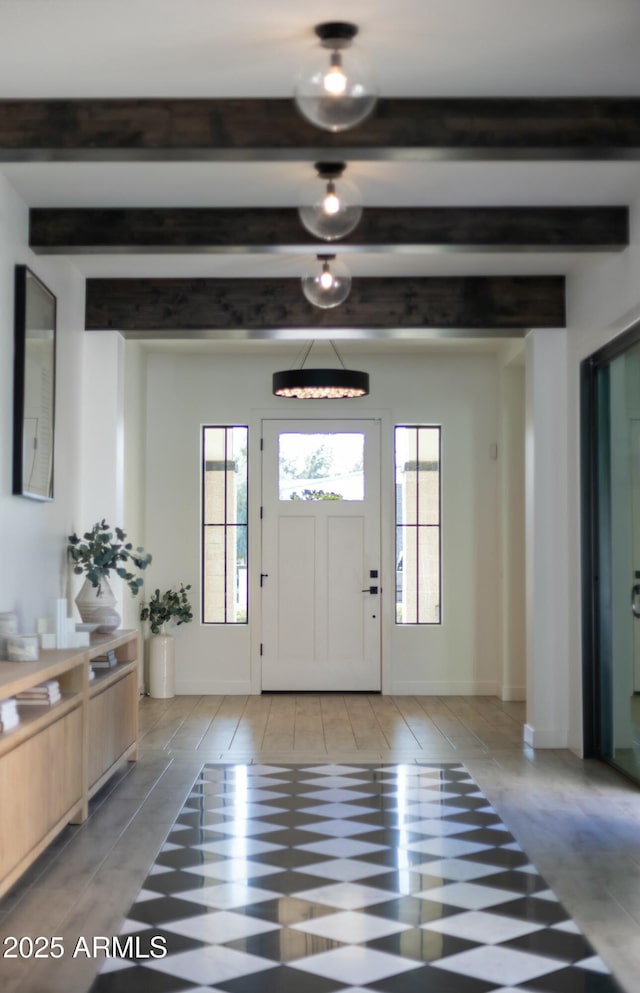 entryway featuring beamed ceiling and baseboards