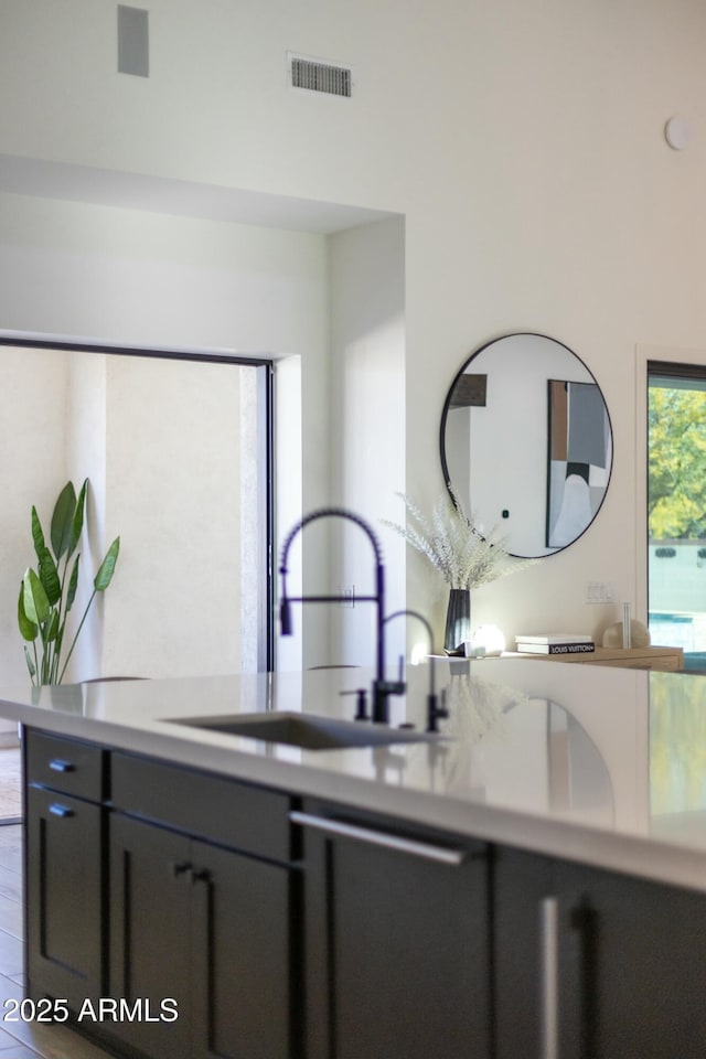 kitchen with light countertops, a sink, visible vents, and gray cabinetry