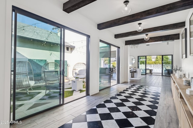 entryway with beam ceiling and baseboards