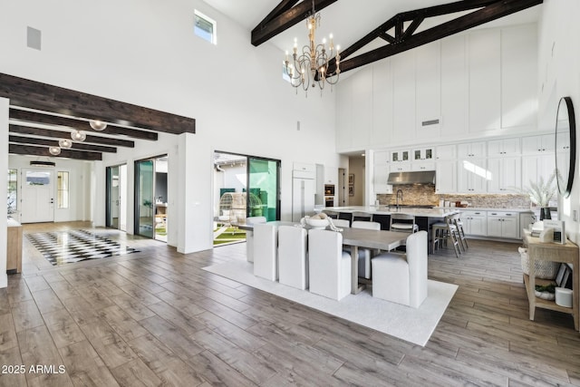 kitchen with visible vents, an island with sink, wood finished floors, light countertops, and under cabinet range hood