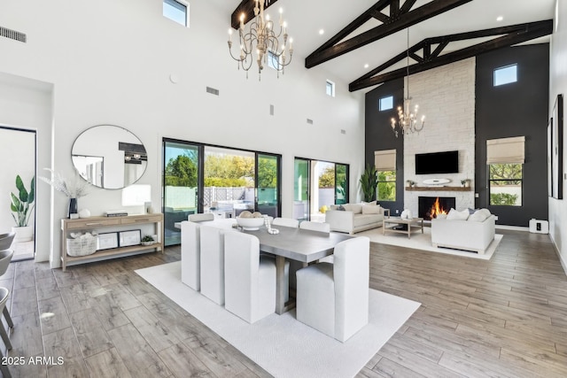 dining space with a chandelier, a fireplace, wood finished floors, and visible vents