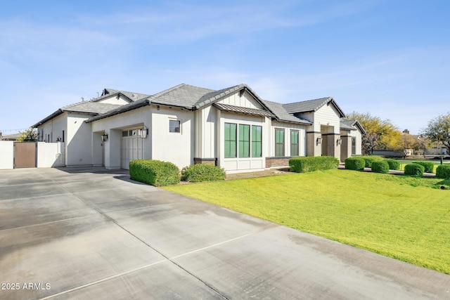 modern farmhouse featuring a garage, concrete driveway, a standing seam roof, fence, and a front lawn