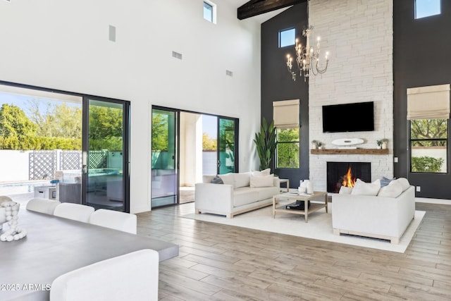 living room featuring plenty of natural light, a fireplace, a chandelier, and wood finished floors