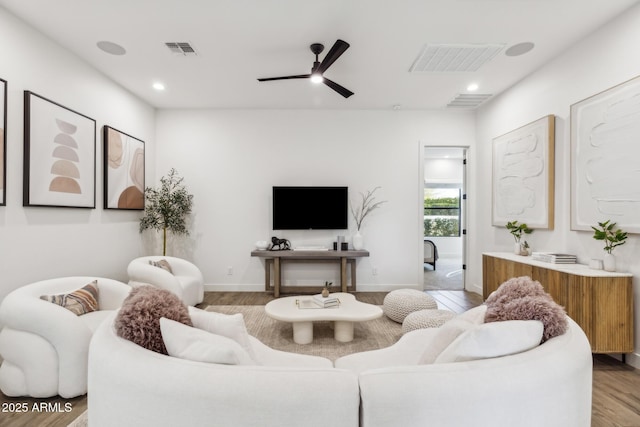 living area with ceiling fan, baseboards, visible vents, and light wood-style floors