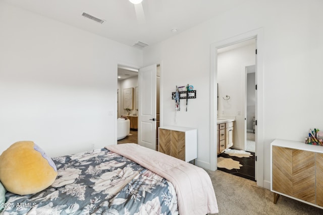 bedroom featuring light carpet, ceiling fan, visible vents, and ensuite bathroom