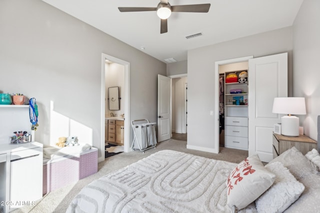 bedroom with a closet, light colored carpet, visible vents, a spacious closet, and connected bathroom