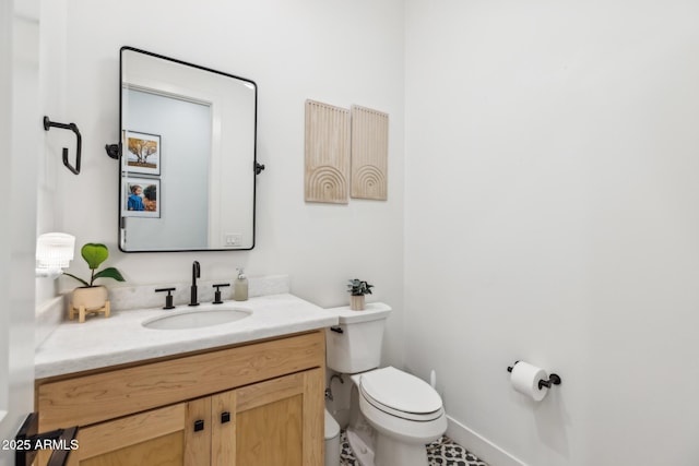 half bathroom with toilet, baseboards, and vanity