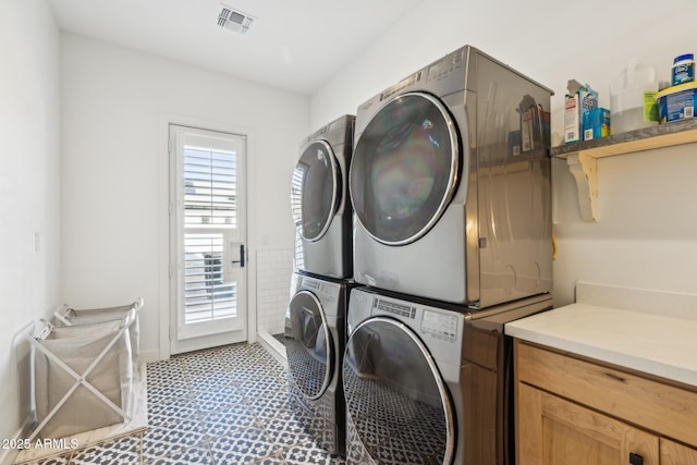 laundry room featuring laundry area, visible vents, and stacked washer / dryer