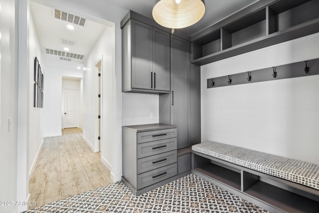 mudroom with light wood-style floors, recessed lighting, visible vents, and baseboards