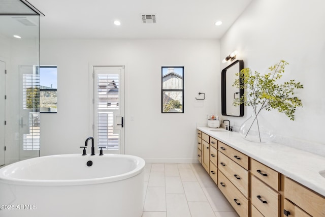 full bath with recessed lighting, a soaking tub, visible vents, and double vanity