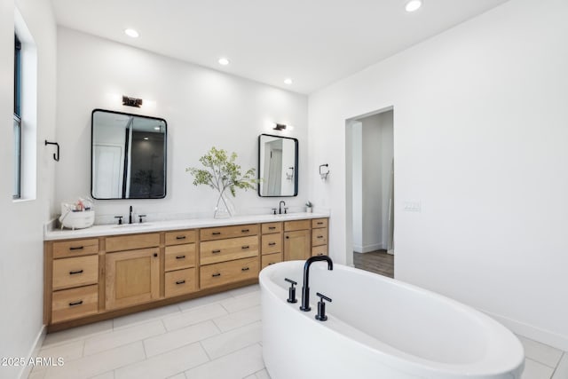 bathroom with double vanity, a soaking tub, tile patterned floors, a sink, and recessed lighting