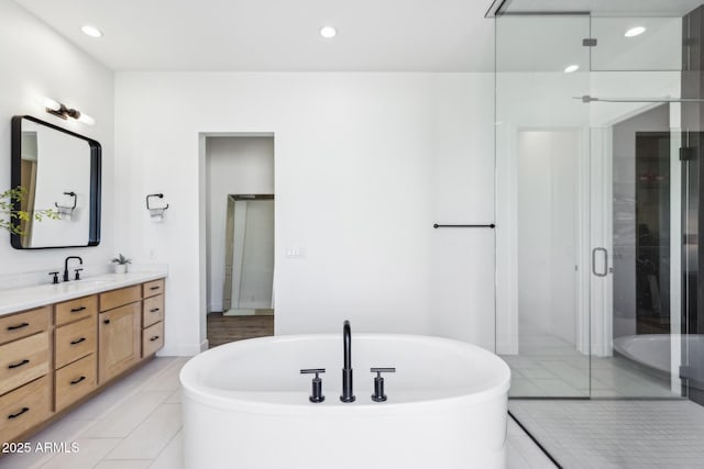 full bath with recessed lighting, a soaking tub, vanity, and a shower stall