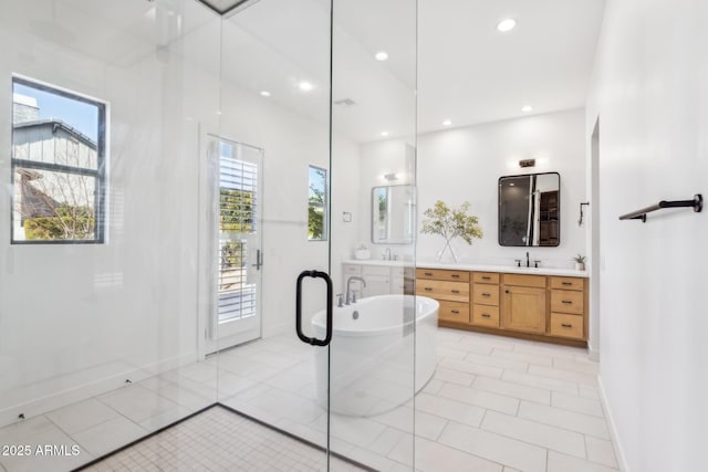 bathroom with tile patterned flooring, a freestanding bath, vanity, and recessed lighting