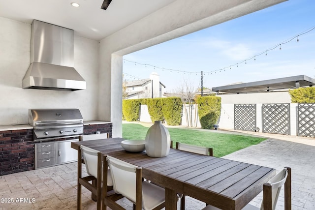 view of patio / terrace featuring outdoor dining area, fence, grilling area, and an outdoor kitchen