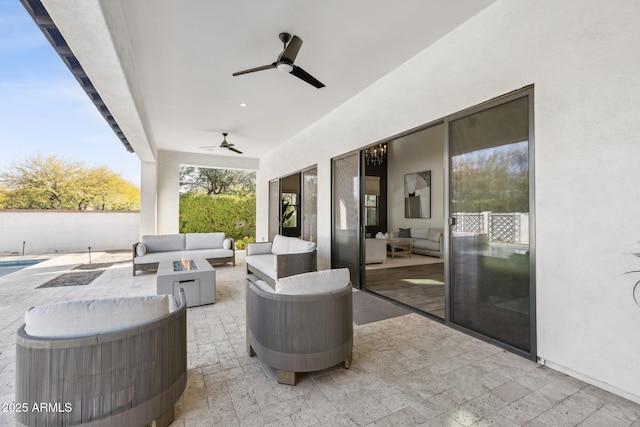 view of patio / terrace featuring a ceiling fan and an outdoor living space with a fire pit