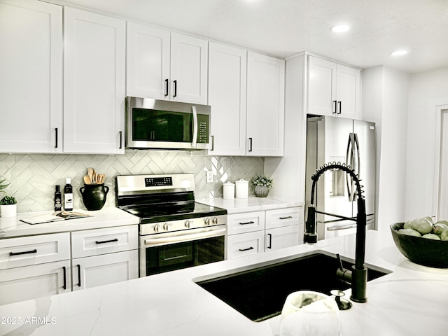 6401 E Eugie Ter, Scottsdale, AZ 85254 - kitchen featuring appliances with stainless steel finishes, white cabinetry, tasteful backsplash, a sink, and recessed lighting