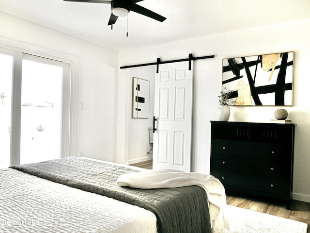 6401 E Eugie Ter, Scottsdale, AZ 85254 - bedroom with a barn door, wood finished floors, baseboards, and ceiling fan