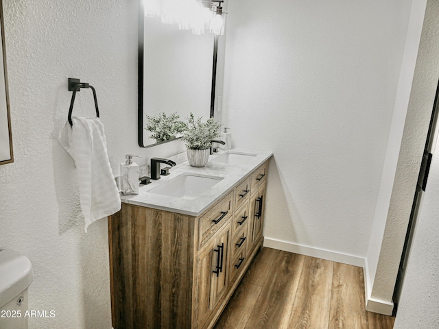 6401 E Eugie Ter, Scottsdale, AZ 85254 - bathroom with double vanity, wood finished floors, toilet, baseboards, and a textured wall