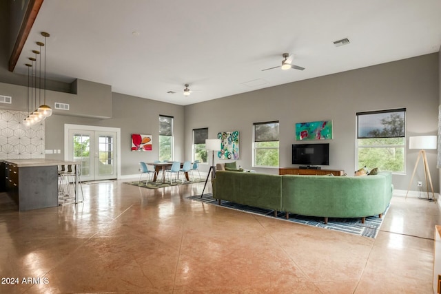 living room with ceiling fan, plenty of natural light, and french doors