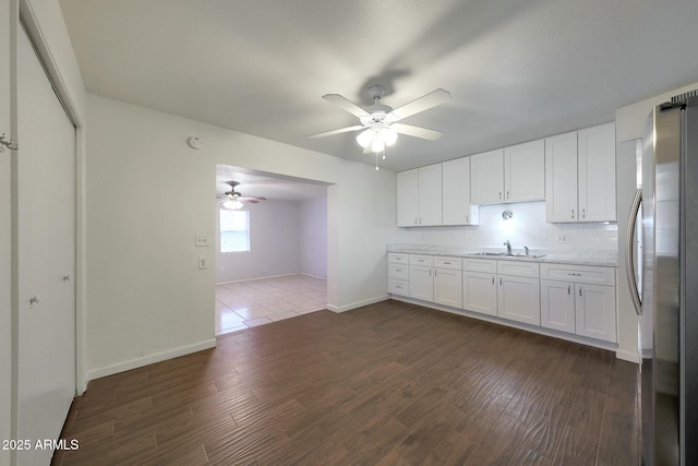 kitchen featuring a sink, ceiling fan, white cabinetry, dark wood-style floors, and freestanding refrigerator
