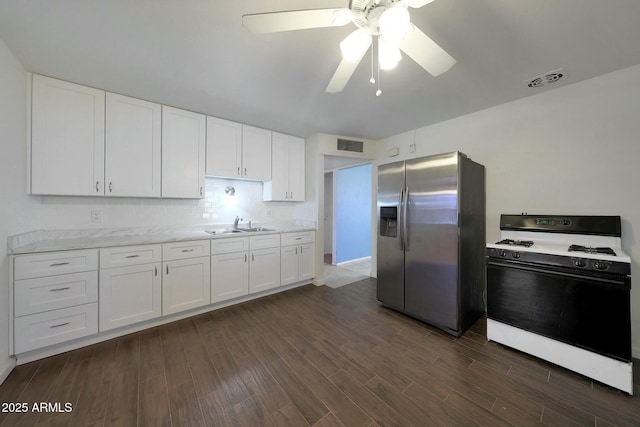 kitchen featuring white cabinets, dark wood-style floors, stainless steel fridge with ice dispenser, visible vents, and gas range gas stove