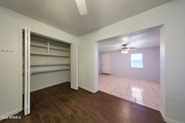 interior space with baseboards, wood finished floors, and ceiling fan