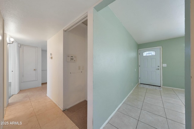 entrance foyer featuring light tile patterned flooring and baseboards