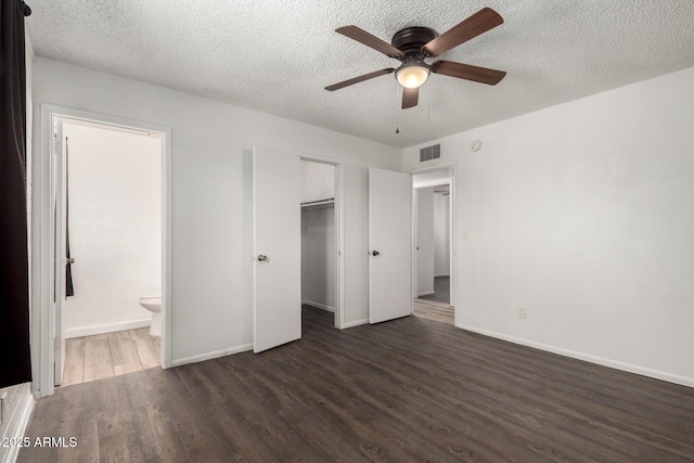 unfurnished bedroom featuring visible vents, baseboards, a textured ceiling, and wood finished floors