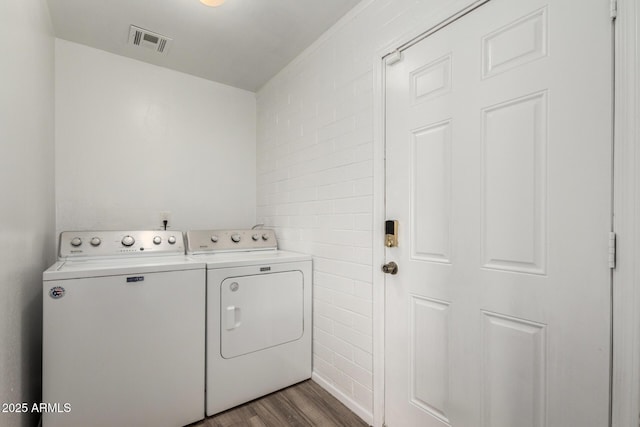 laundry area featuring laundry area, washing machine and dryer, dark wood-type flooring, and visible vents