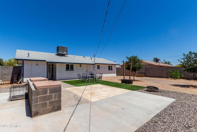 rear view of house featuring a fenced backyard, a patio area, and cooling unit