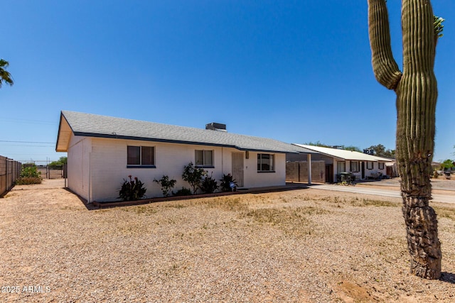 ranch-style house featuring fence