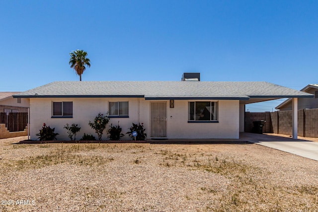 single story home with fence, an attached carport, brick siding, a shingled roof, and driveway