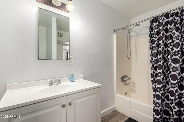full bathroom with visible vents, wood finished floors, shower / tub combo, and vanity