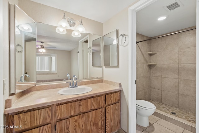 bathroom with vanity, visible vents, a tile shower, tile patterned flooring, and toilet