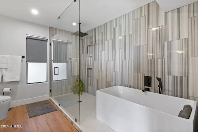 bathroom featuring hardwood / wood-style flooring, toilet, and shower with separate bathtub