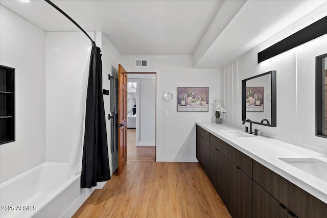 bathroom with shower / bath combo with shower curtain, wood-type flooring, and vanity