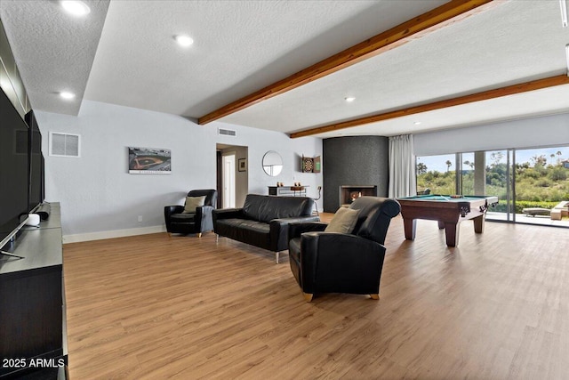 living room with beamed ceiling, light hardwood / wood-style floors, a textured ceiling, and billiards