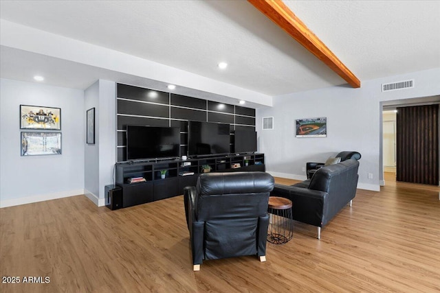 living room with hardwood / wood-style flooring, beam ceiling, built in features, and a textured ceiling