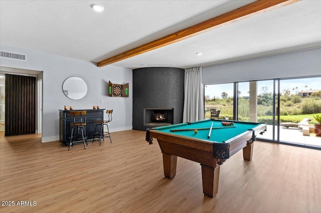 rec room with beamed ceiling, light wood-type flooring, a fireplace, and billiards