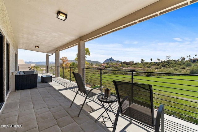 view of patio / terrace featuring a mountain view, an outdoor hangout area, and a balcony